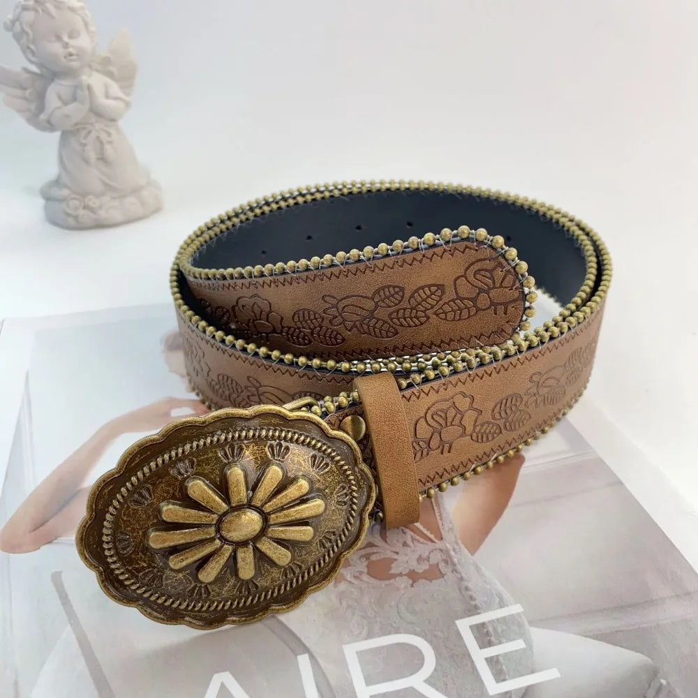 A vintage PU leather boho western belt with a gold sunburst buckle displayed on a white surface.