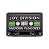 A black enamel pin featuring the text JOY DIVISION and UNKNOWN PLEASURES with colored stripes and circular dials.