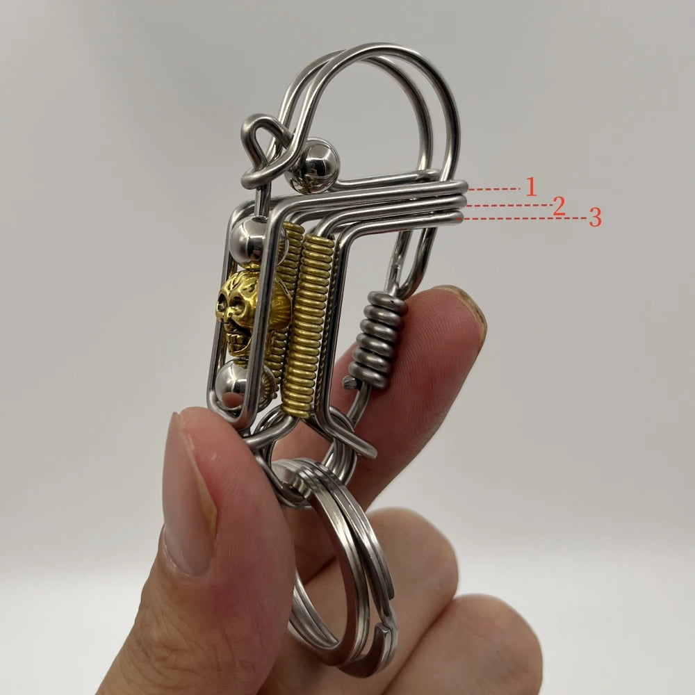 Porte-clés mécanique en acier inoxydable avec un design de crâne et mécanisme à ressort.