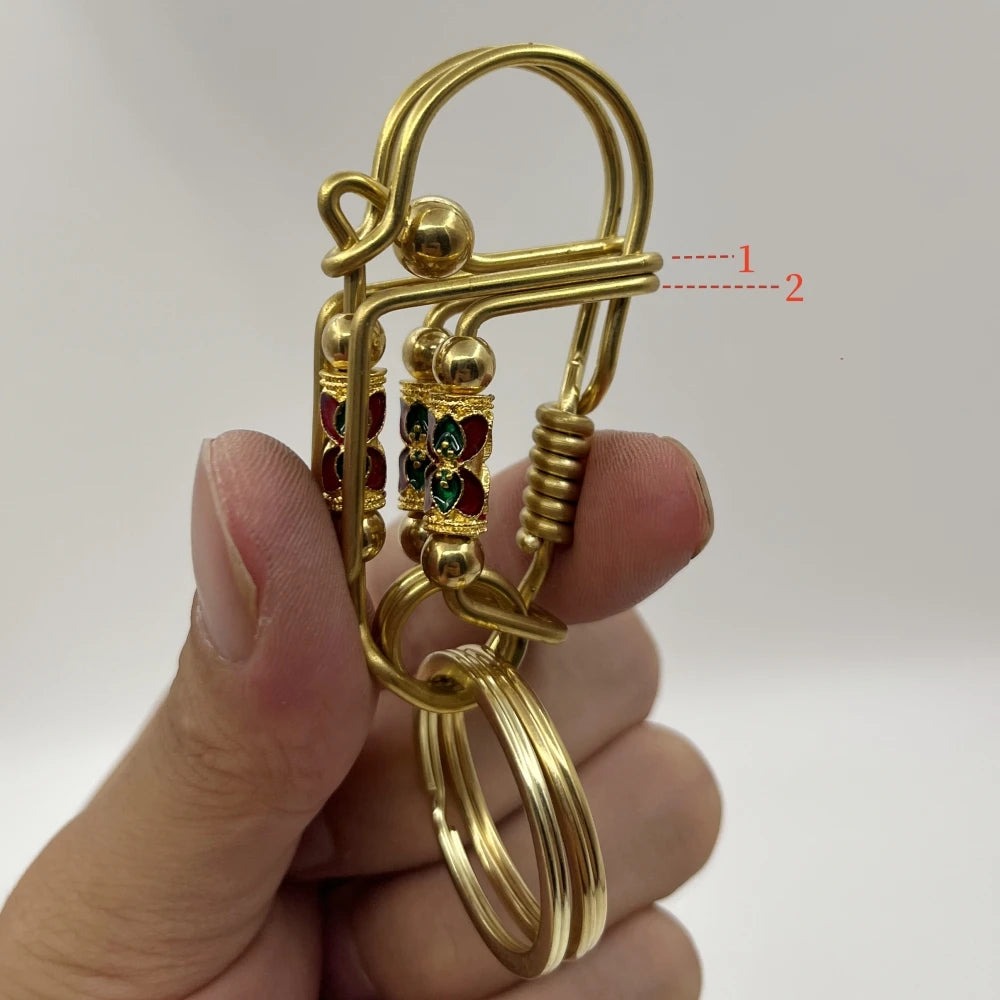 Une main tient une clé USB mécanique en acier inoxydable doré avec des éléments décoratifs.