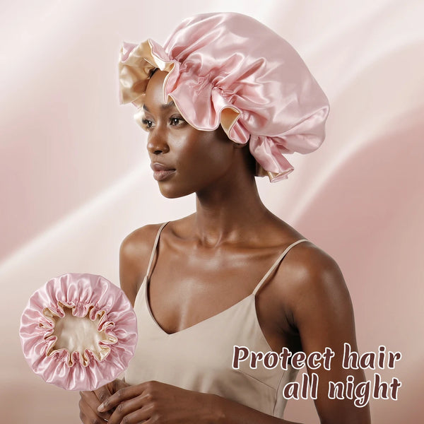 A model wears a pink satin sleeping bonnet hair cap while looking to the side.