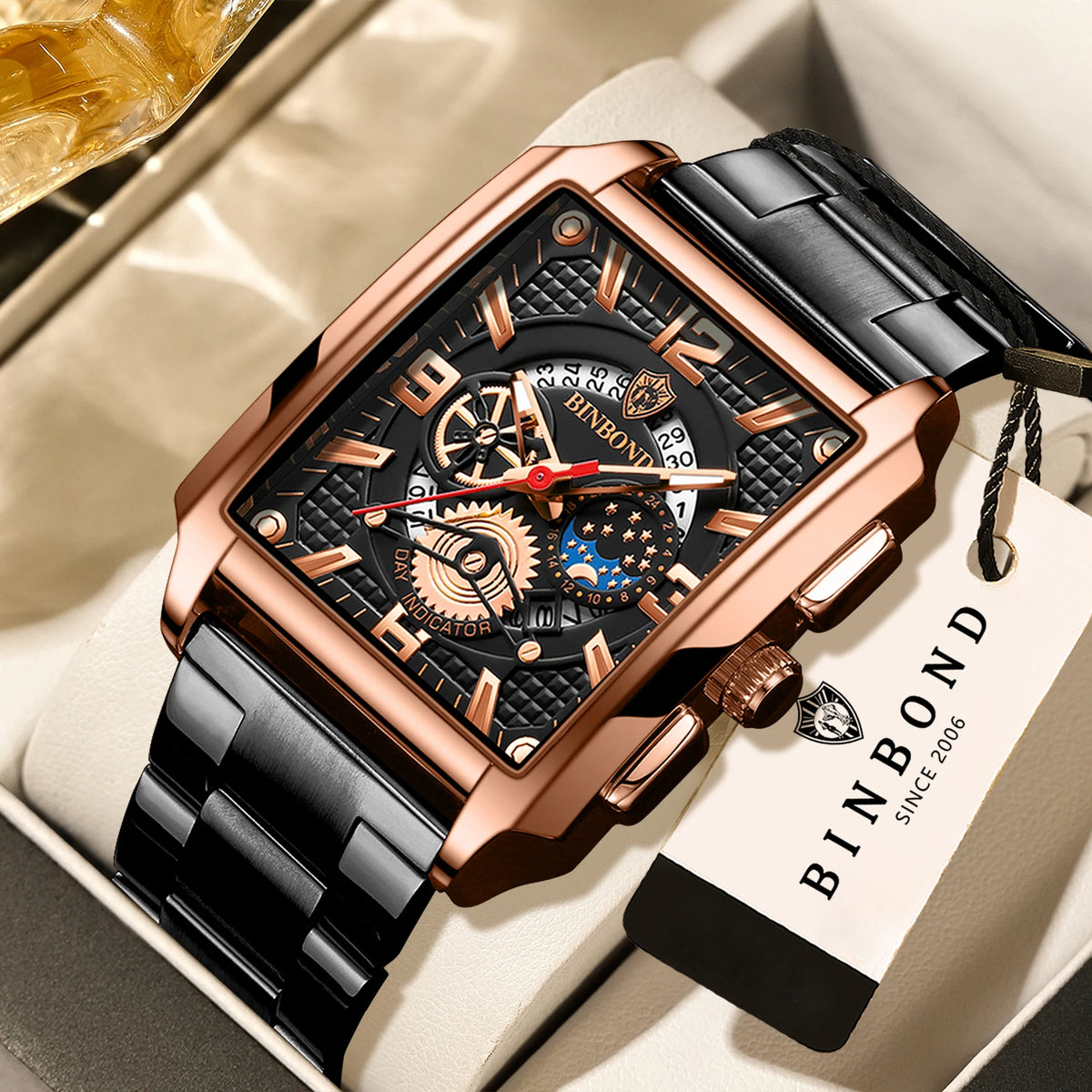Nahaufnahme einer roségoldenen und schwarzen Uhr mit Lederarmband, die in einer hellen Box liegt.
