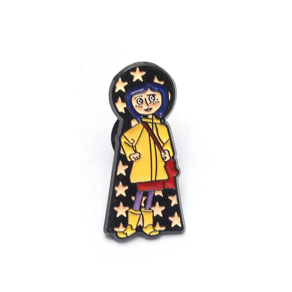 Broche émail noire avec un personnage de dessin animé stylisé, cheveux bleus et vêtements jaunes entourés d'étoiles.