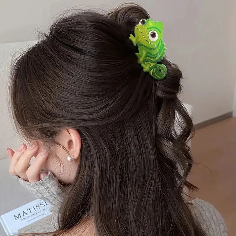 A woman's dark hair is styled in an updo with a bright green lizard clip accessory.