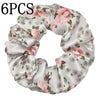Seis gomas de tela satinada con estampado floral en tonos rosa y verde.