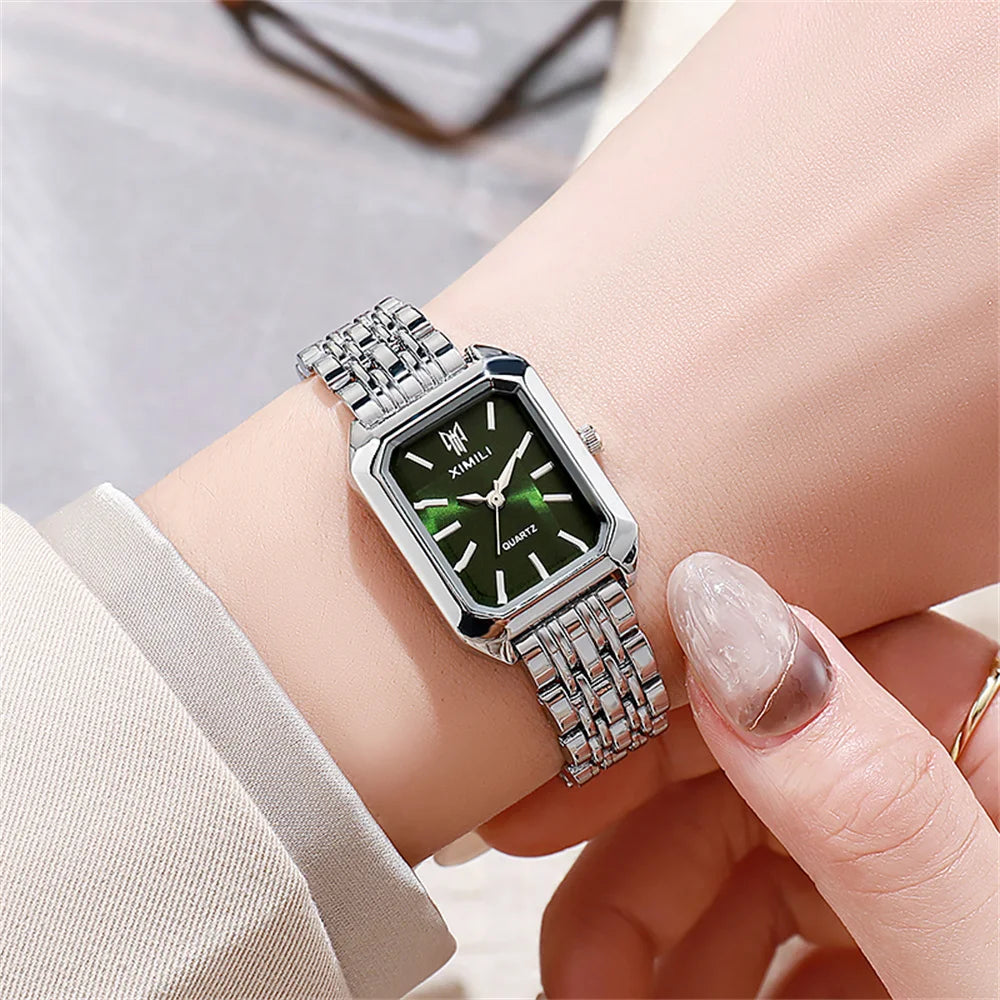 A close-up of an elegant gold-plated quartz fashion watch worn on a wrist against a light background.