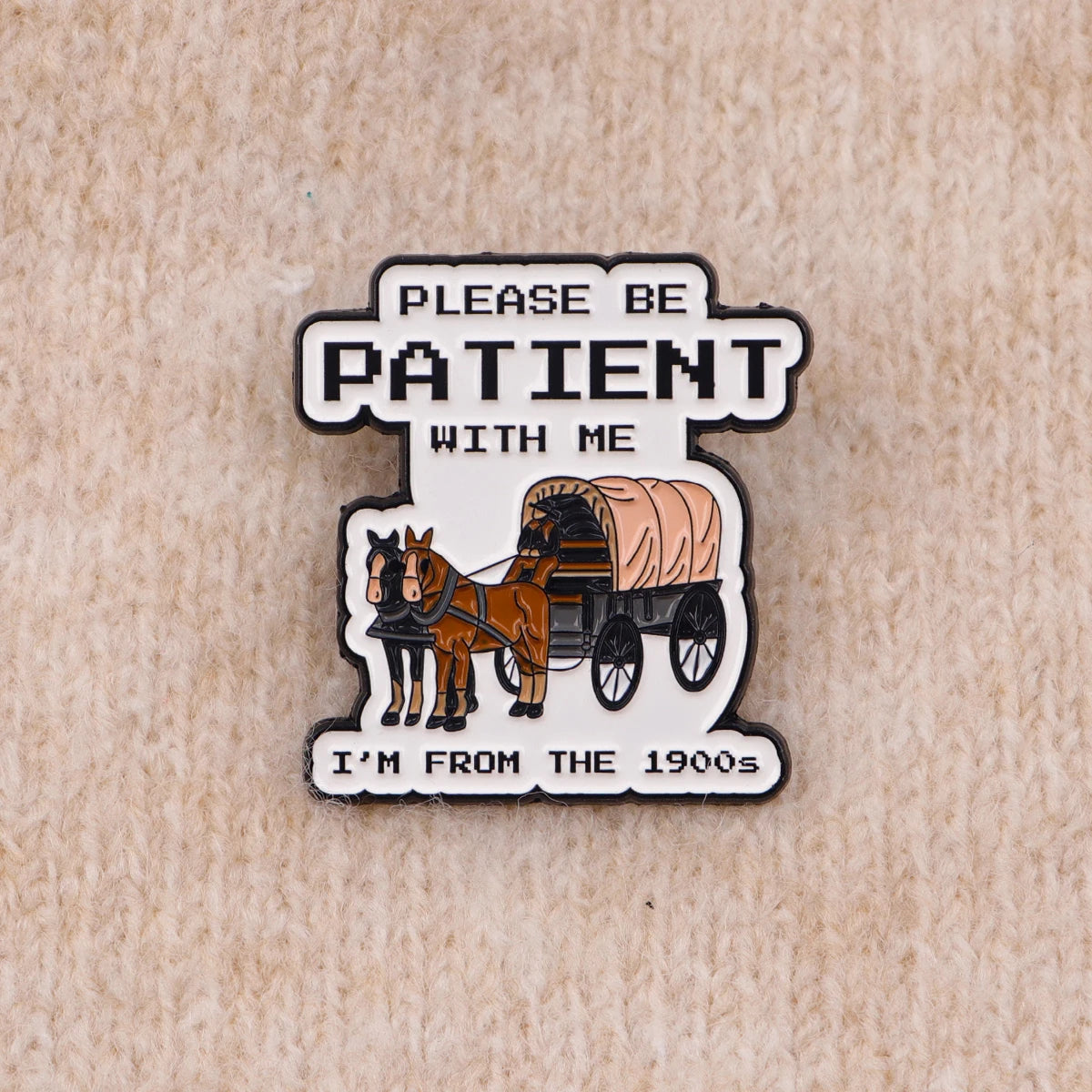 An enamel pin featuring a silhouette of horses and the text PLEASE BE PATIENT WITH ME I'M FROM THE 1900s