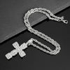 Silver rhinestone cross pendant necklace laid on a dark surface.