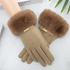Tan suede gloves with fluffy brown faux fur cuffs resting on a white surface.