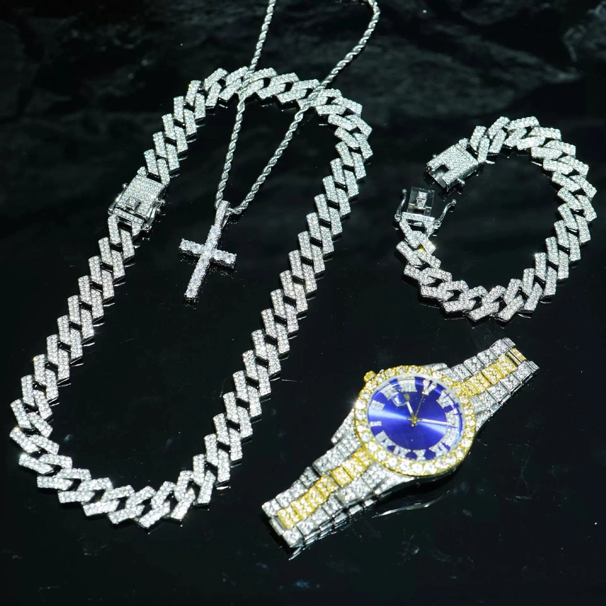 A set of silver diamond chains including a long necklace, a bracelet, and a wristwatch.