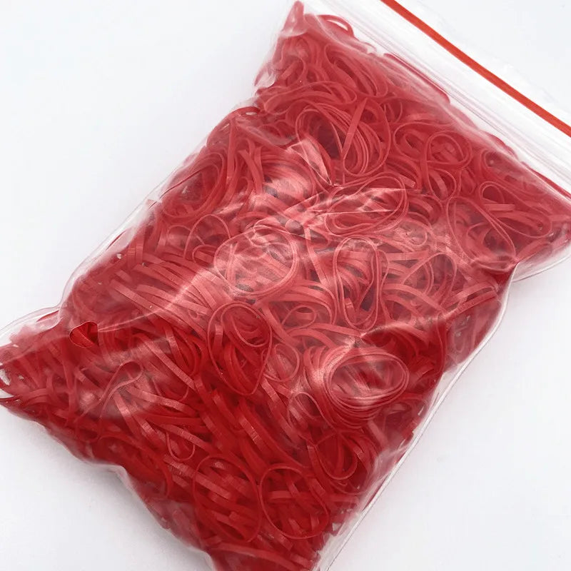 A clear plastic bag filled with red disposable hair scrunchies for ponytail holders
