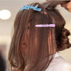 A set of light blue and purple professional multifunctional hair sectioning clips used for styling hair.