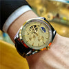 A close-up of a gold-toned luxury automatic mechanical men's wristwatch on a person's wrist.