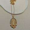 A dainty golden Christian necklace featuring a figure of the Virgin Mary surrounded by small stones.