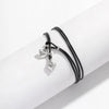 A black leather anklet with silver heart charms is shown on a white wrist.
