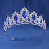 A sparkling crystal rhinestone tiara and headband set featuring blue gemstones against a blue background.