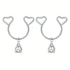 A pair of silver heart dangle non-piercing nipple rings adorned with cubic zirconia stones.