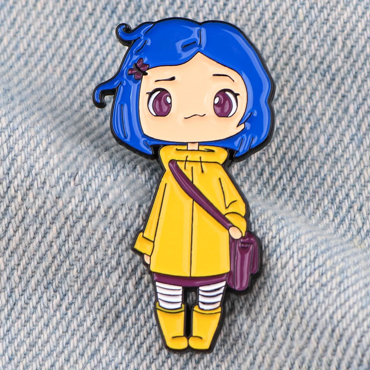 Emaille-Anstecker mit einem Chibi-Charakter mit blauem Haar und gelber Kleidung.