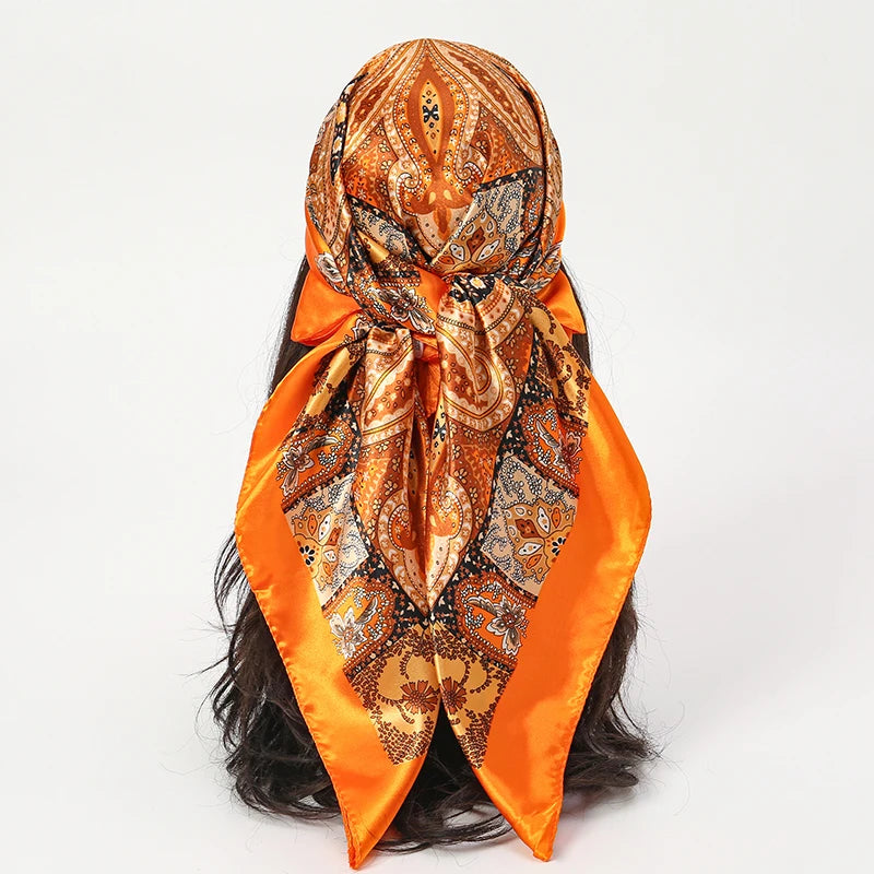 A luxurious orange and gold satin silk scarf tied around a dark hair