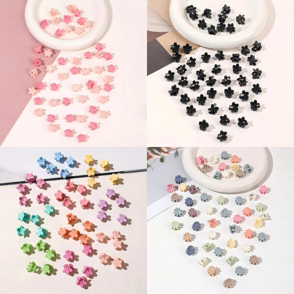 A set of colorful mini flower hair clips in various shades of pink, purple, and yellow scattered on a white background.