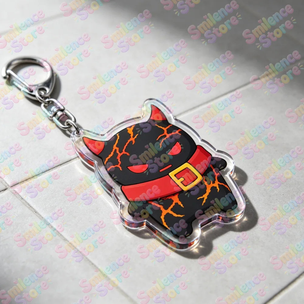A clear plastic keychain featuring a black cat face with orange eyes and an orange belt detail.