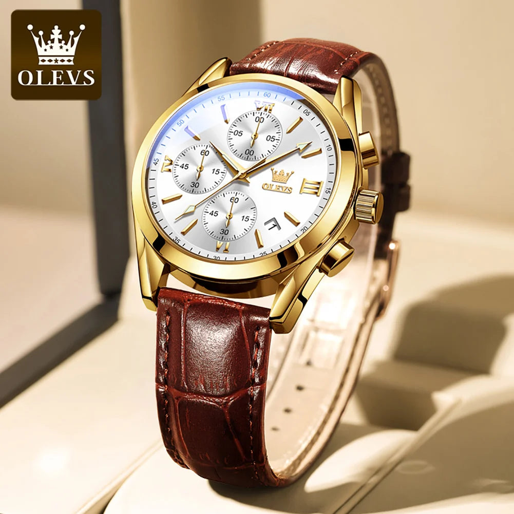 A gold-toned chronograph wristwatch with a white dial and brown leather strap is shown on a wrist.