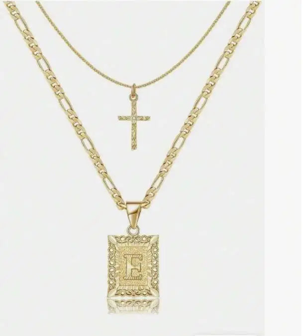 Collier en forme de lettre E dorée avec un pendentif croix sur une chaîne délicate