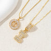 Gold-toned necklace set featuring CZ crystal pendants shaped like letters, displayed on a light background.