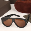 Black oversized pilot sunglasses with brown lenses resting on a white surface.