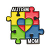 A puzzle piece lapel pin featuring the words AUTISM and MOM with heart shapes in yellow, blue, red, and green colors.