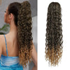A woman shows off a long, wavy hair extension in shades of brown and blonde.