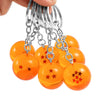 A hand holds a silver chain with multiple round, orange-colored charms featuring small red stars.