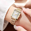 Primer plano de un reloj analógico de cuarzo tono dorado con caja plateada y esfera blanca, llevado en una muñeca.