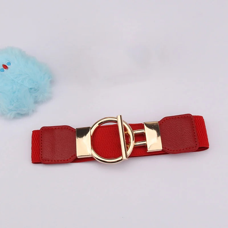 A red adjustable fashion belt with a gold buckle and a light blue fluffy pom-pom.