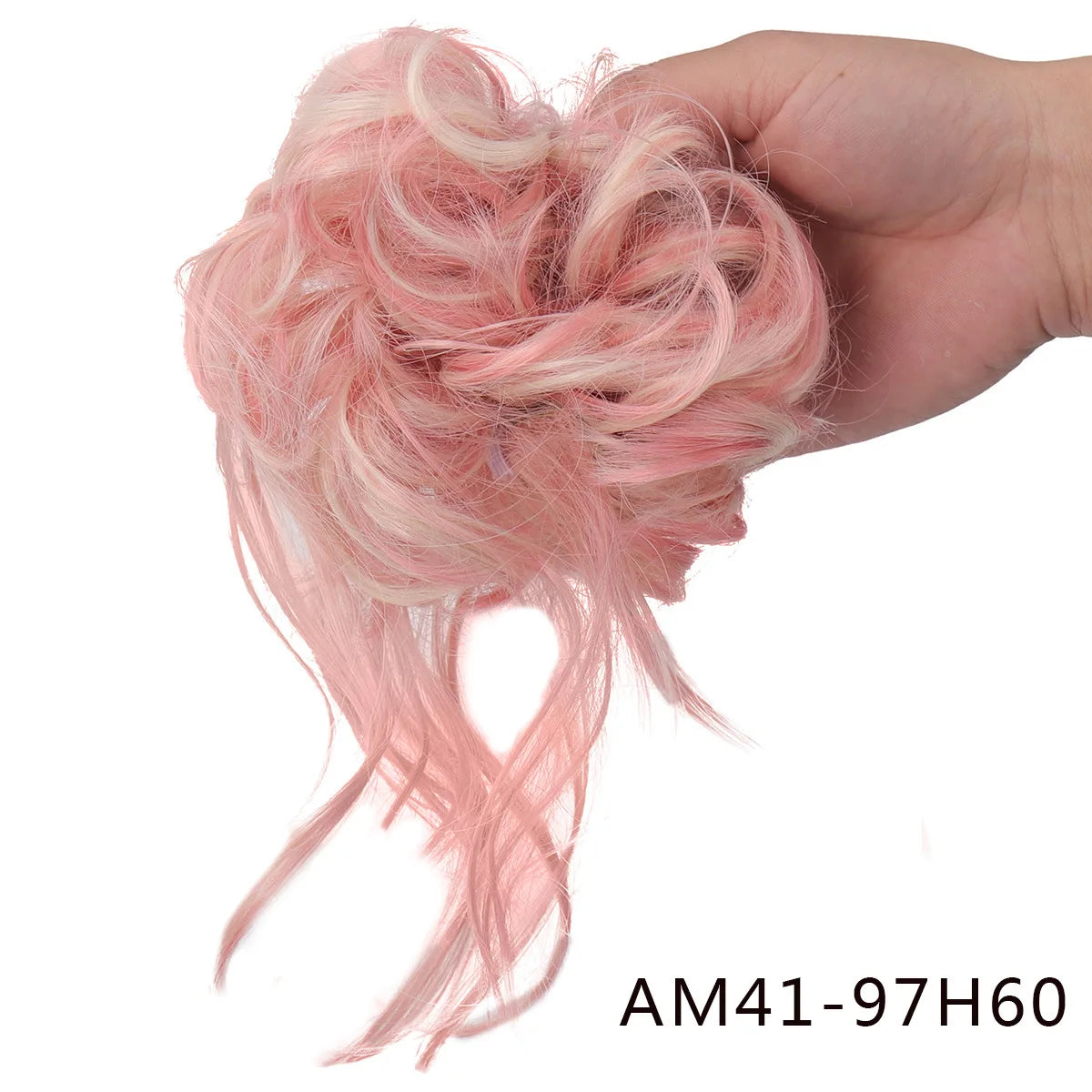 A hand holds a pink messy synthetic hairpiece bun for women