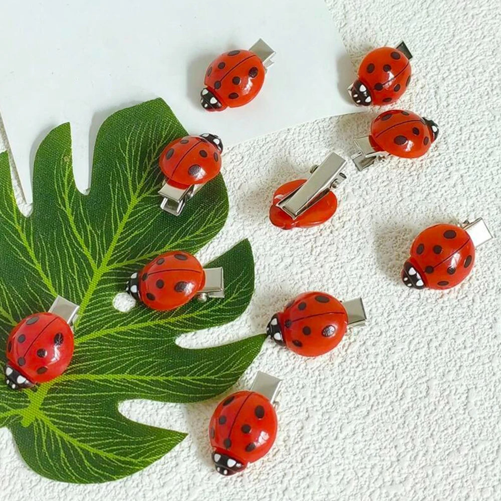 A set of ten cute ladybug hair clips in bright orange and black on a white background.