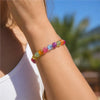 Handgelenk mit einem Strang farbiger UV-reaktiver Perlen, einschließlich grün, gelb, orange und pink