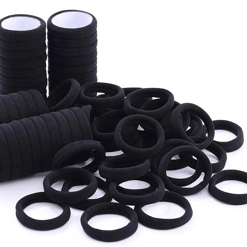 A collection of black elastic hair ties in various sizes and styles for ponytails and buns.