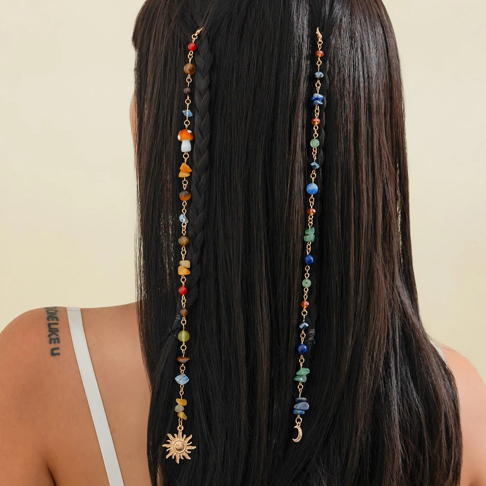 A woman shows off long black hair adorned with a bohemian sun moon tassel hair headdress.