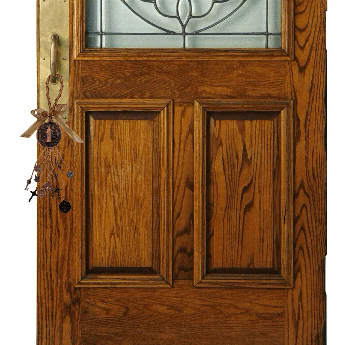 A wooden door with a glass panel and a brass hardware featuring a Saint Benedict protection charm set.
