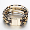 Pile de bracelets en cuir tube à motif léopard bohème avec accents dorés.