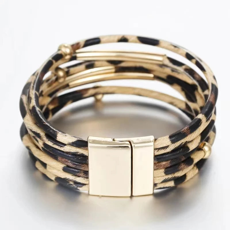 Pile de bracelets en cuir tube à motif léopard bohème avec accents dorés.