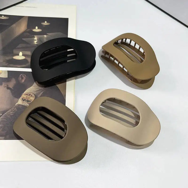 Three flat oval hair claw clips in matte olive green and black are displayed on a white background.