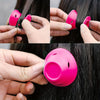A set of bright pink heatless magic hair curlers being used to curl dark hair.