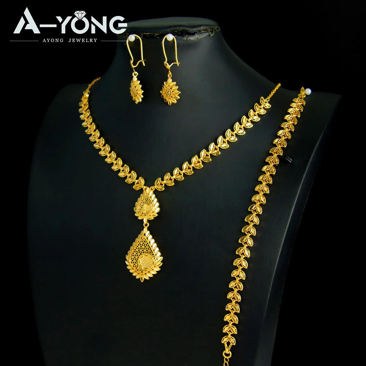 A set of luxury gold plated bridal jewelry featuring a necklace and matching earrings displayed on a black mannequin.