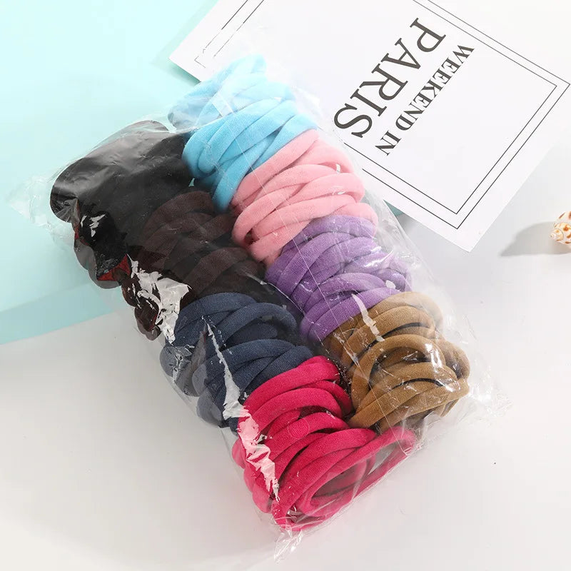 A bundle of colorful elastic hair ropes in various shades including blue, pink, purple, and brown, packaged for sale.