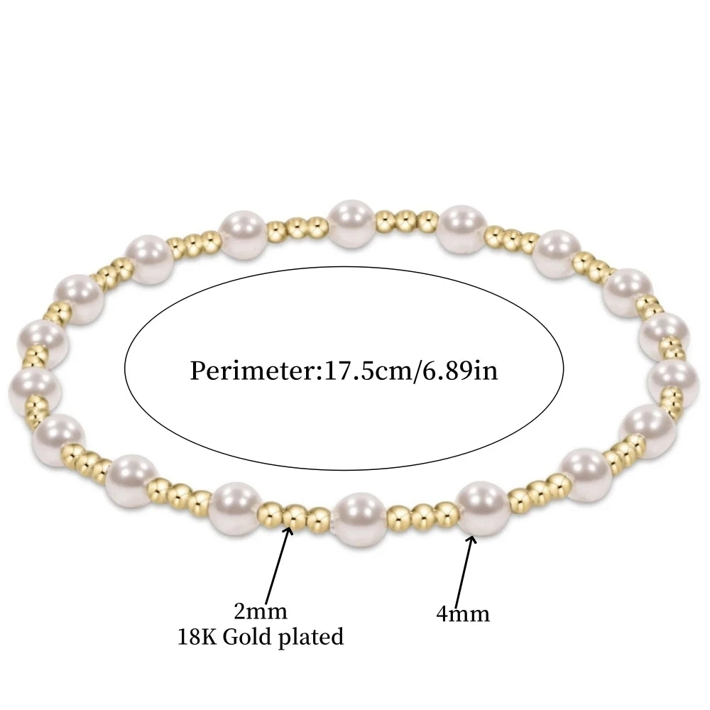 Une rangée de petites perles blanches rondes sur un bracelet doré avec une épaisseur de placage de 2 mm.
