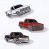 A collection of three metal clip pins depicting various truck models in retro Mexico style.