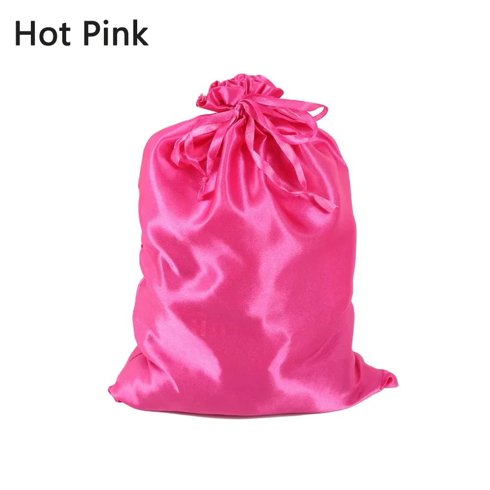 A bright pink satin drawstring storage bag for hair tools.