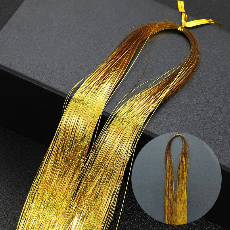 Golden rainbow glitter hair extensions strands laid out on a dark surface.
